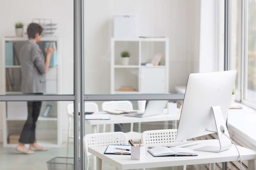 An image of a clean and spotless office space with a woman standing inside it